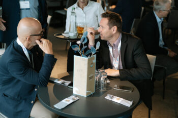 Zwei Männer sitzen an einem Tisch und sprechen miteinander